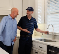 Zoomed-in image of Grande Aire employee wearing blue gloves testing home water