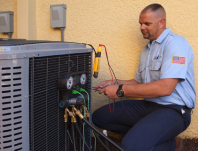 Grande Aire technician performing a seasonal tune-up on an AC unit